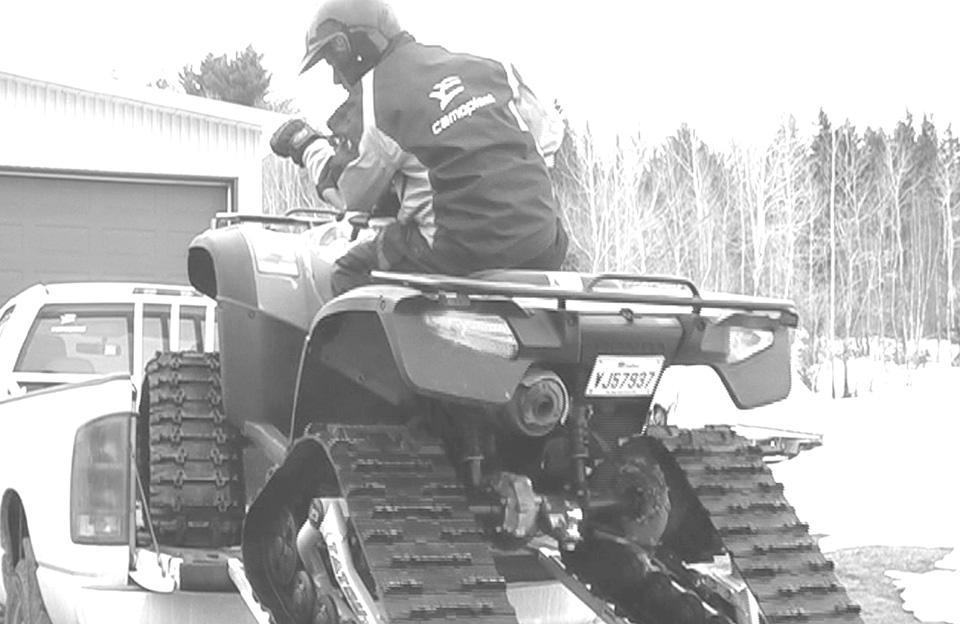 USING THE ATV WITH TRACKS Loading a vehicle into and unloading it from a