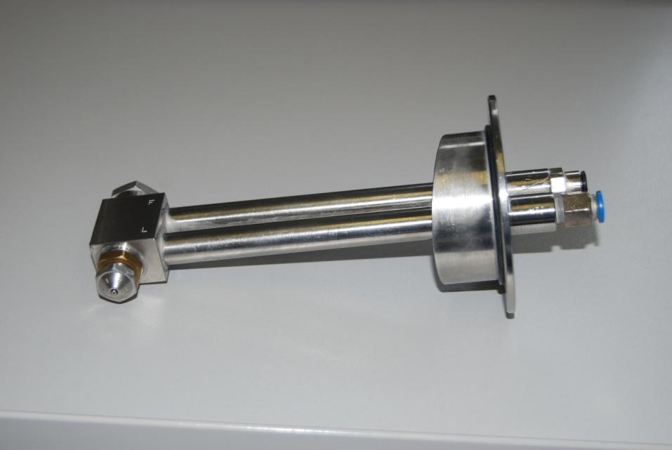 jednom cijevi spojen je na peristaltičku pumpu pomoću koje se dozira vezivo dok se druga cijev spaja na kompresor kojim se kontrolira tlak zraka za raspršivanje.