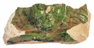 Green-glazed tile showing a human face with wings in the background (Excavation documentation archives, Novigrad na Dobri). Slika 13.
