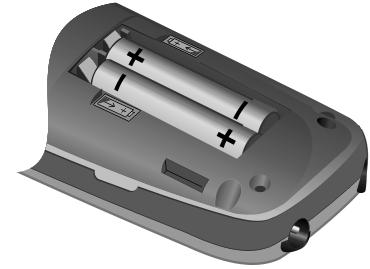 Поларитет је означен у лежишту батерија. Прво поравнајте избочине са стране поклопца батерије са зарезима унутар кућишта.